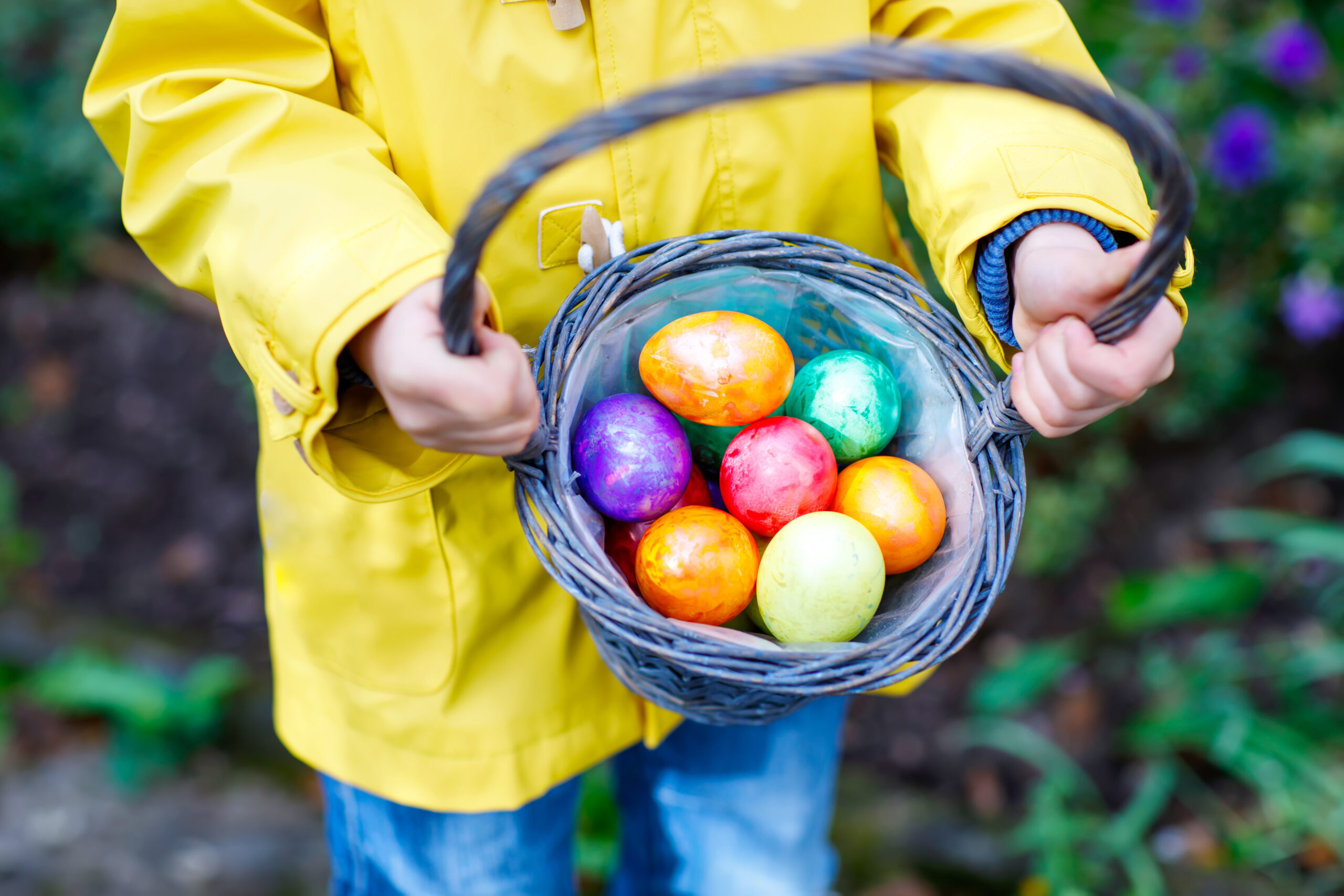 Child holding basket of Easter eggs